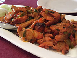Spicy chicken sandheko Nepali appetizer tossed with onions, chili, and Himalayan spices